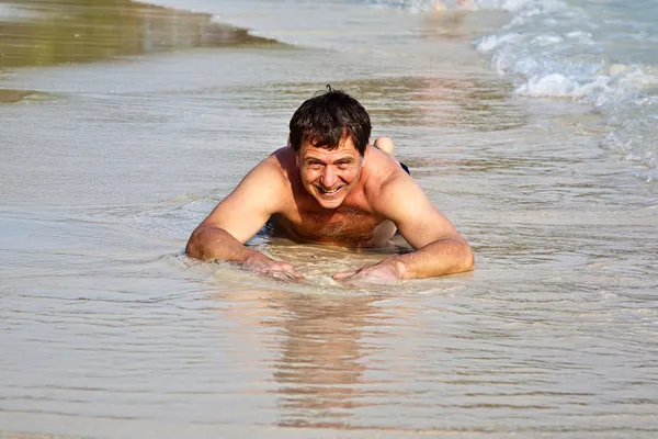 Człowiek leżący na plaży — Zdjęcie stockowe