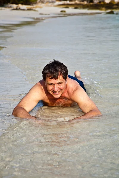 男子躺在沙滩上 — 图库照片