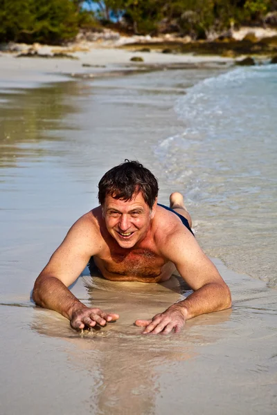 Muž ležící na pláži — Stock fotografie