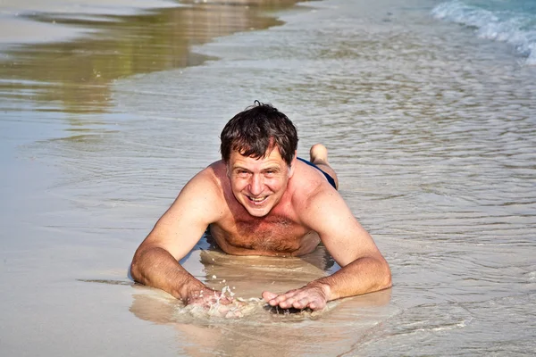 Homem deitado na praia — Fotografia de Stock