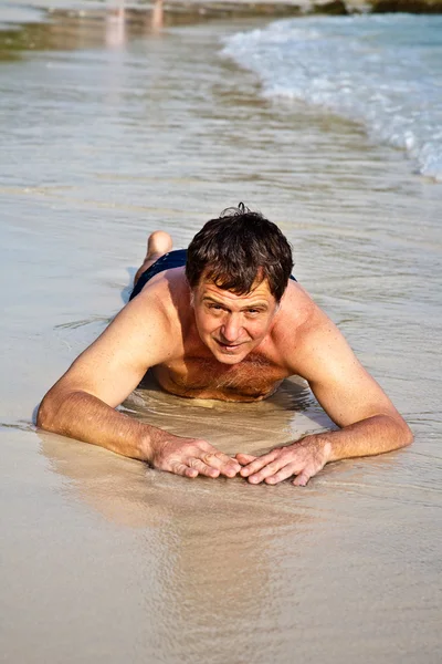 Muž ležící na pláži — Stock fotografie
