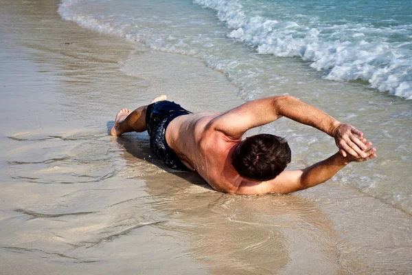 Mann liegt am Strand — Stockfoto