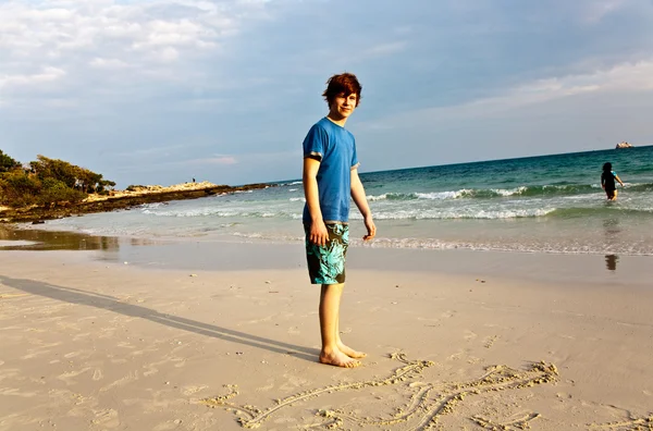 Mladý chlapec s červenými vlasy se těší na krásnou pláž a malba v sa — Stock fotografie