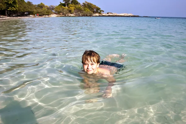 Αγόρι έχει διασκέδαση στον ωκεανό θαυμάσια ζεστό και απολαμβάνει το νερό — Φωτογραφία Αρχείου