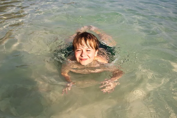 Αγόρι έχει διασκέδαση στον ωκεανό θαυμάσια ζεστό και απολαμβάνει το νερό — Φωτογραφία Αρχείου