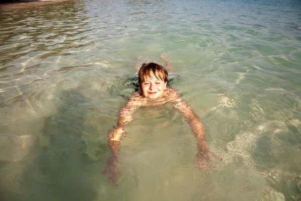Çocuk harika ılık okyanusa eğlenir ve su sever — Stok fotoğraf