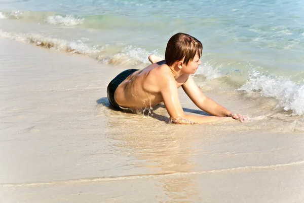 Мальчик веселится в прекрасном теплом океане и наслаждается водой — стоковое фото