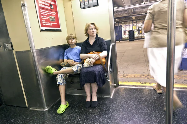 Ребенок с матерью, сидящей в метро — стоковое фото