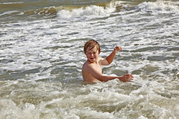 Мальчик наслаждается волнами в диком океане — стоковое фото
