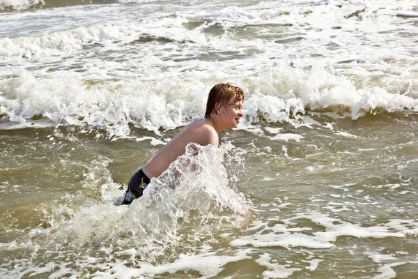 Pojken njuter av vågorna i vilda havet — Stockfoto