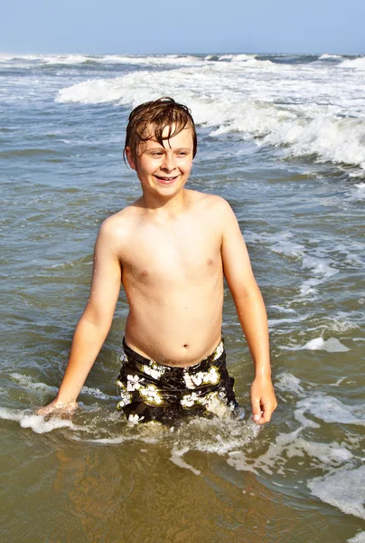 Хлопчик насолоджується хвилями в дикому океані — стокове фото