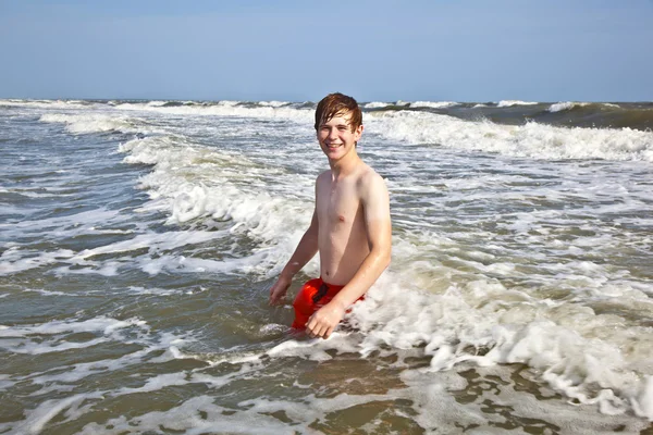 Хлопчик насолоджується хвилями в дикому океані — стокове фото