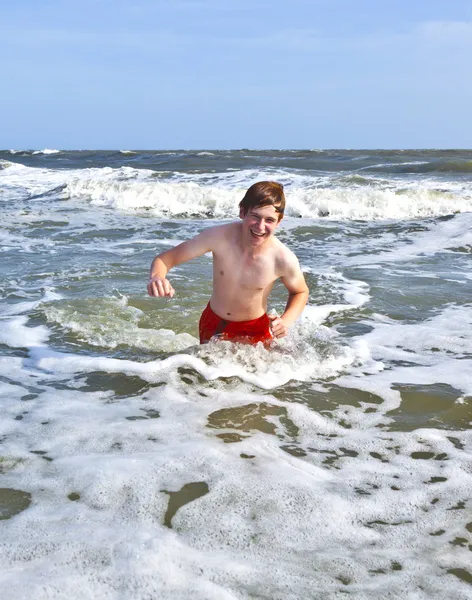 Chłopiec znajduje się plaża i morze — Zdjęcie stockowe