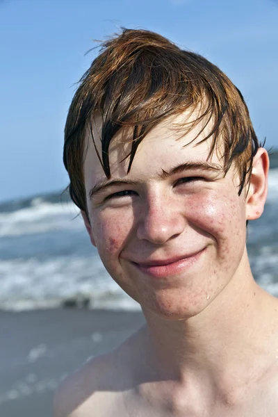 Счастливый мальчик с мокрыми волосами на пляже — стоковое фото