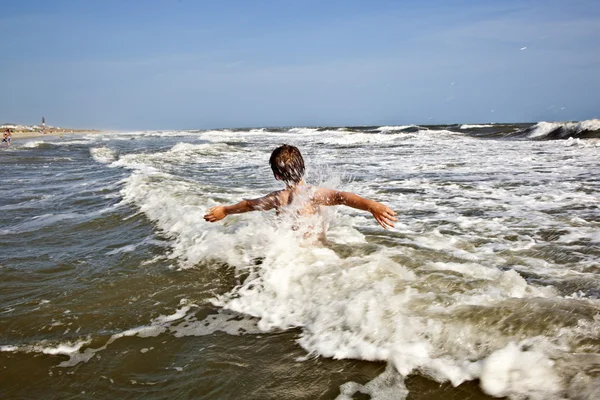 Boy enjoying the waves in the wild ocean Stock Photo