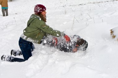 Children have a snowball fight in the white snowy area clipart