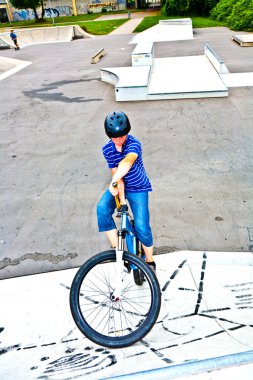 Boy on his bike at the skate park clipart