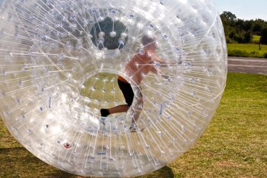 Child has a lot of fun in the Zorbing Ball clipart