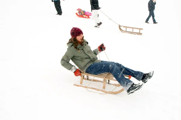 Menina gosta de trenó no inverno na bela neve branca — Fotografia de Stock