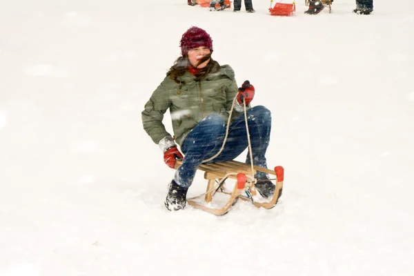 Girl enjoys sledging in winter on beautiful white snow — Stock Photo, Image