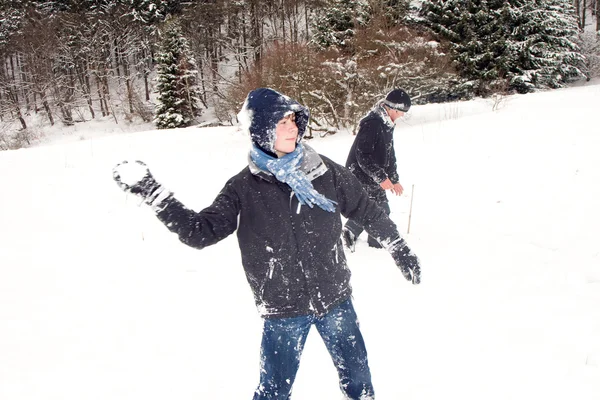 Niños tienen una pelea de bolas de nieve en la hermosa zona blanca nevada —  Fotos de Stock