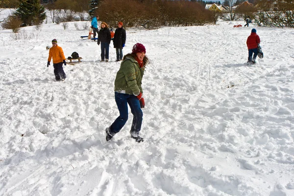 Barn har ett snöbollskrig i området vit snöig — Stockfoto