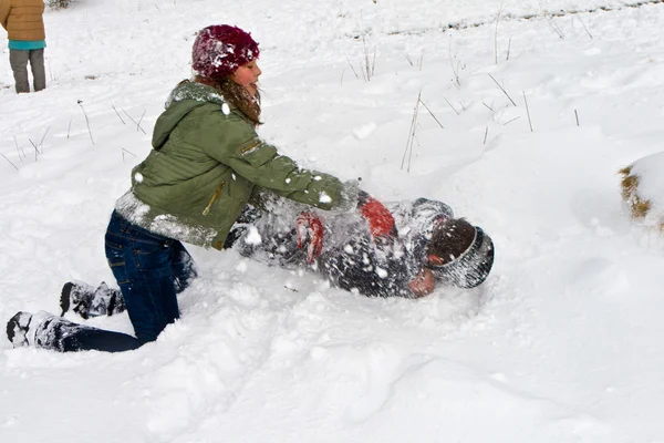 I bambini hanno una lotta con la palla di neve nella bianca area innevata — Foto Stock