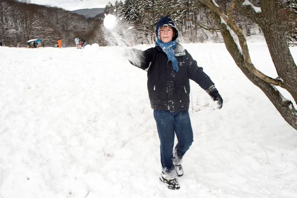 Kinder haben eine Schneeballschlacht in der weißen, schneebedeckten Gegend — Stockfoto