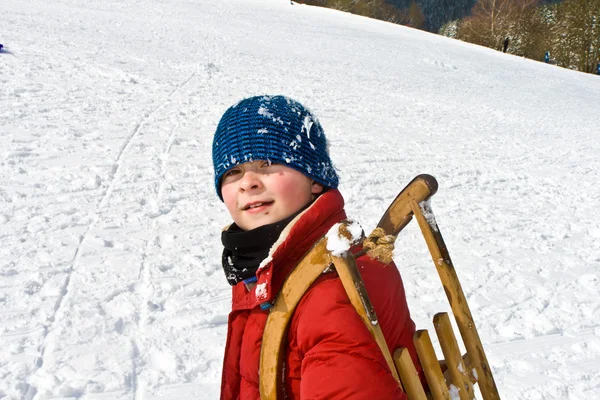 Boy is carrying his sledge — Stock Photo, Image