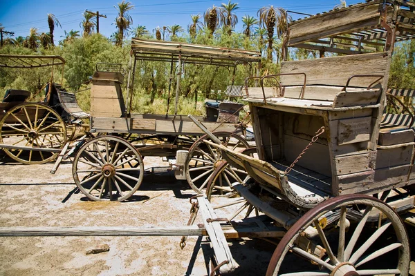 Old wagon and coaches at the entrance of the Furnance Creek Ranch in the mi — Stock Photo, Image