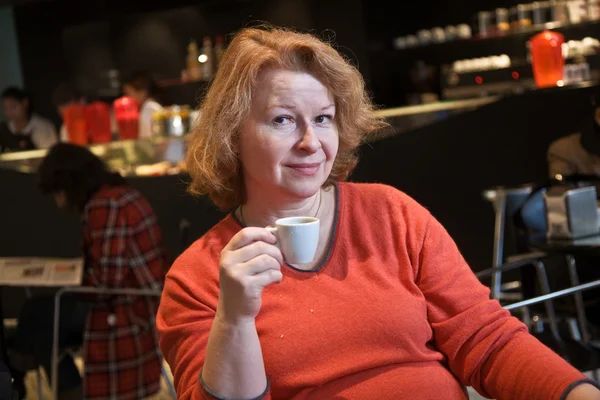 Aardige dame geniet van een kopje koffie in een coffee bar — Stockfoto
