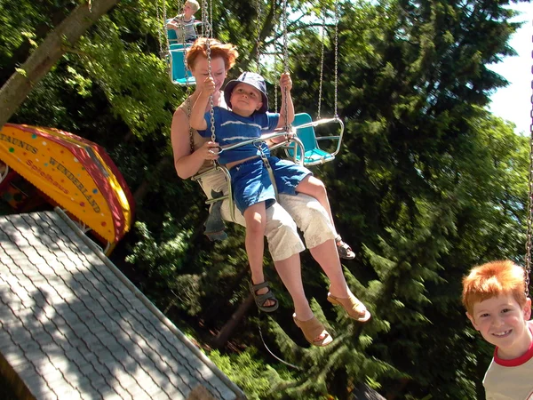 Niño con madre divertirse en la silla del carrusel —  Fotos de Stock