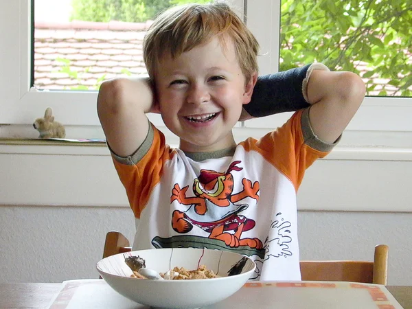 Niño en el desayuno con yeso en su brazo roto —  Fotos de Stock