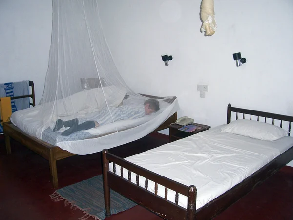 Мальчик спит в москитной сетке в отеле — стоковое фото
