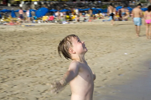 Fröhlicher Junge schreit, wenn er ins Meerwasser läuft — Stockfoto