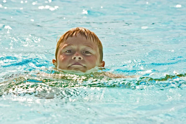 Мальчик веселится, плавая — стоковое фото