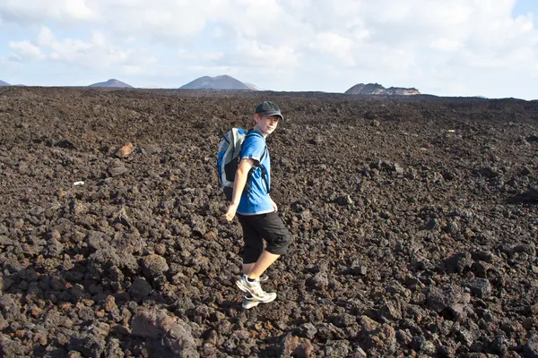 Jongen op trail wandelen in de vulkanische gebied in lanzarote — Stockfoto