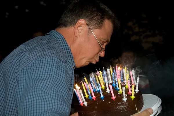 Man blaast zijn birthday kaarsen — Stockfoto