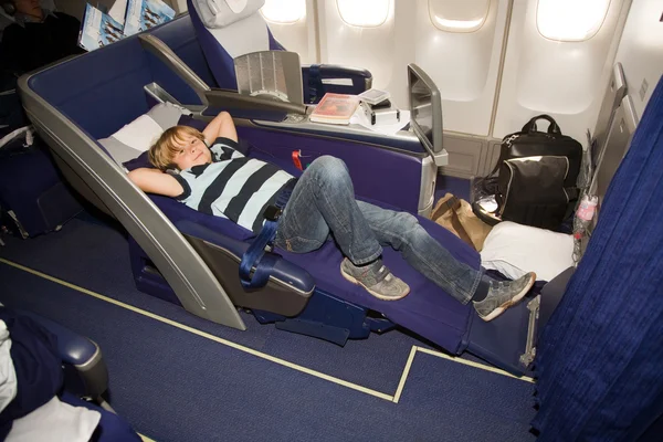 Boy relaxing in a business class seat — Stock Photo, Image