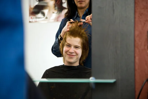 Souriant jeune garçon aux cheveux roux chez le coiffeur — Photo