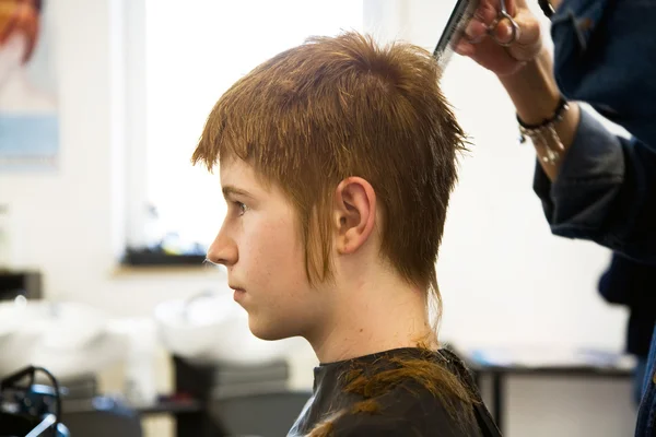 Souriant jeune garçon aux cheveux roux chez le coiffeur — Photo