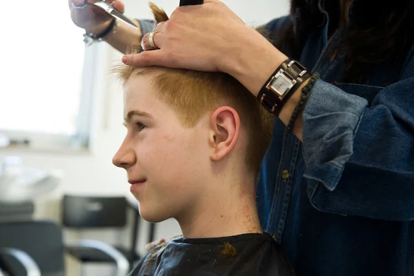 Smiling young boy with red hair at the hairdresser — Stock Photo, Image
