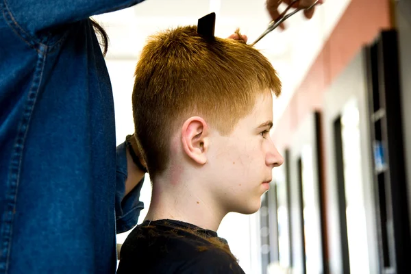 Smiling young boy with red hair at the hairdresser — Stock Photo, Image