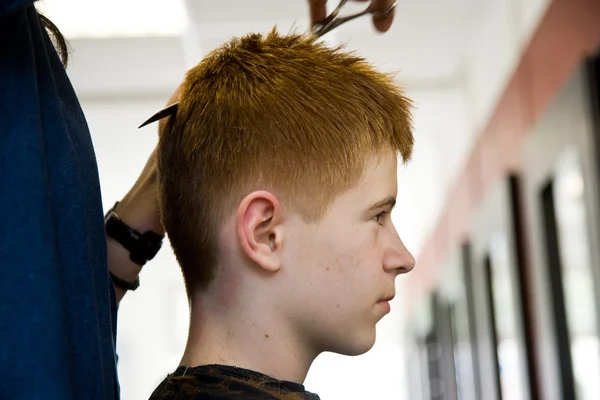 Uśmiechający się młody chłopak z czerwone włosy u fryzjera — Zdjęcie stockowe