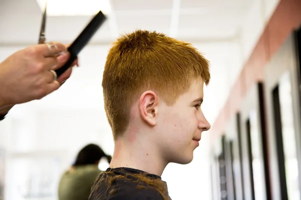 Sorridente giovane ragazzo con i capelli rossi al parrucchiere — Foto Stock