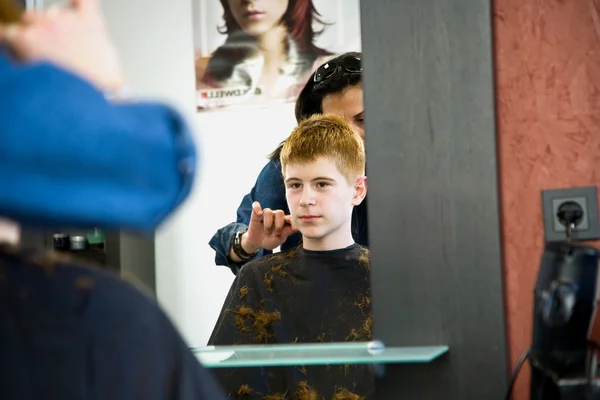 Улыбающийся мальчик с рыжими волосами у парикмахера — стоковое фото