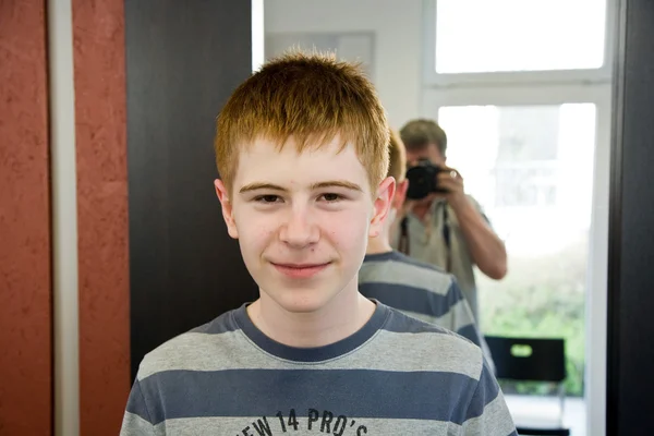 Garotinho sorridente com cabelo vermelho no cabeleireiro — Fotografia de Stock