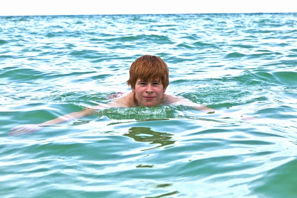 Kind schwimmt im Ozean — Stockfoto