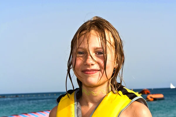 Meisje met leven vest op het strand — Stockfoto