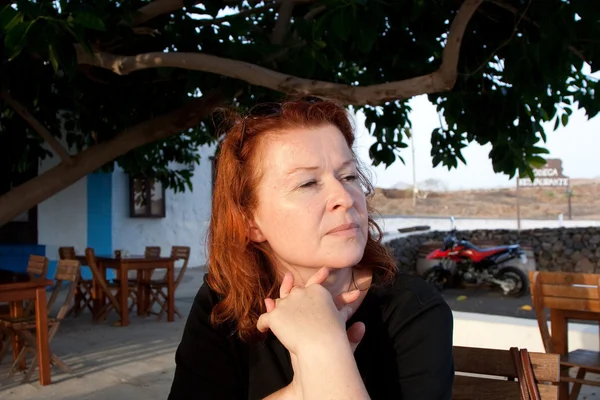 Frau mit roten Haaren wartet im Restaurant auf ihren Service — Stockfoto